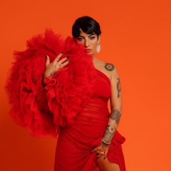 Ana Tijoux in red dress and boa 2023 press photo